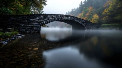 A stone bridge arches over a foggy river, surrounded by autumn trees reflecting in the still water. Concept Stone Bridge Architecture, Foggy River Scenery, Autumn Foliage Reflection