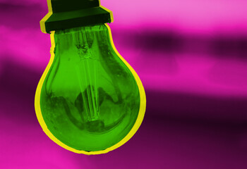 Striking contrast of vibrant artistic green glass bulb hanging in front of a rich pink lila background. Innovation, energy, and futuristic lighting design concept. Copy space
