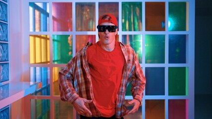 Funny break dancer moving freestyle step to hiphop while looking at camera. Crazy happy hipster dancing and performing street dancing while wear casual outfit and sunglasses in Led light. Regalement.