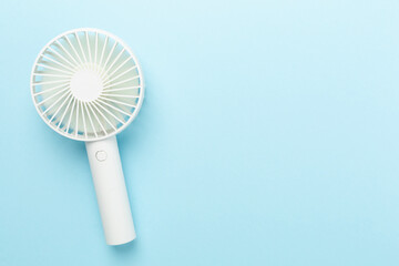 Mini electric fan on color background, top view