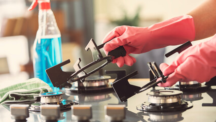 Woman of cleaning cooker indoors at home