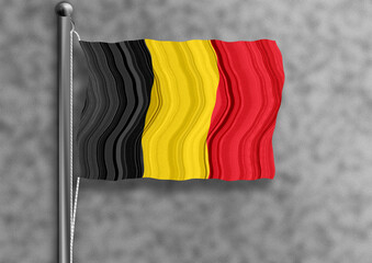 Belgium flag flying on a flagpole, isolated, wall textured background.