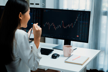 Successful young Asian businesswoman earning highest profit with fist up in exchange stock market...