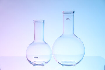 Empty flasks on color background. Laboratory glassware