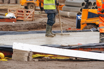 Construction workers pouring concrete on building site