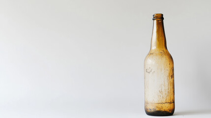A solitary empty beer bottle stands upright on a white background