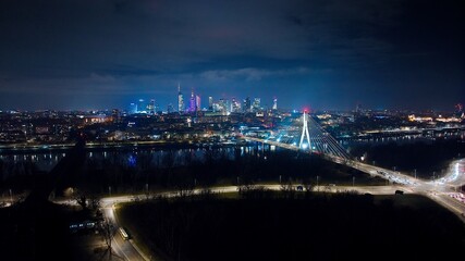 Nighttime Warsaw glows with the Świętokrzyski Bridge, and shining streets filled with life.