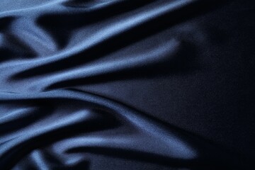 Blue crumpled silk fabric as background, top view