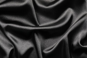 Black crumpled silk fabric as background, top view