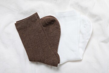 Soft socks on white blanket, top view