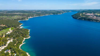 Obraz premium Aerial photo of the stunning Limski Kanal and Camping Koversada near Vrsar, Croatia. The landscape features lush greenery, crystal-clear turquoise waters, and winding coastline — a true Adriatic