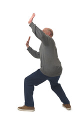 side view of a man standing holding or pushing up something imaginary