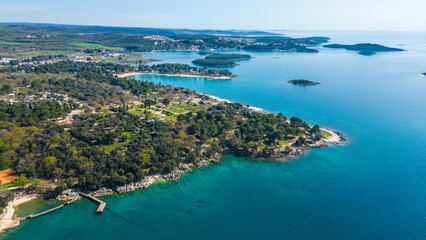 Fototapeta premium Aerial photo of Funtana in Istria, Croatia, featuring Valamar Camping Istra. This picturesque coastal area offers crystal-clear Adriatic waters, lush Mediterranean greenery, and top-class camping 