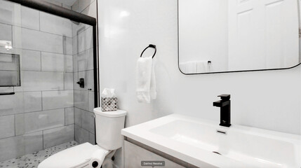 A bathroom that includes a toilet, a sink, a mirror, and a shower area