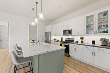 A modern kitchen with white cabinets and stainless steel appliances