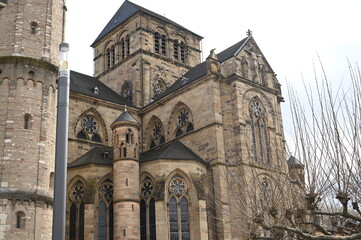 Fototapeta premium Gothic cathedral facade with tall stained glass windows and stone architecture. Historical European church building, detail of wall and arches. Travel and heritage concept.