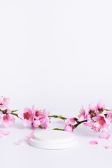 Spring white background with podium or platform and pink flowers vertical photo