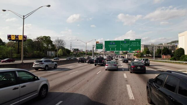 Atlanta, Georgia / United States - April 2, 2025: Car passenger POV point of view moving through heavy car vehicle traffic on multi-lane road and highway infrastructure through big city and town roads