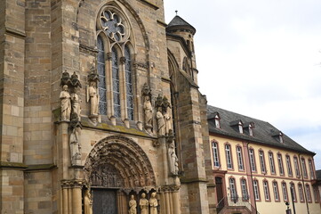 Fototapeta premium Gothic cathedral facade with tall stained glass windows and stone architecture. Historical European church building, detail of wall and arches. Travel and heritage concept.