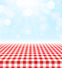 Red checkered tablecloth on sunny picnic background
