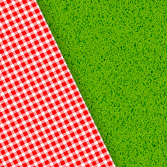 Red and white tablecloth on green grass background
