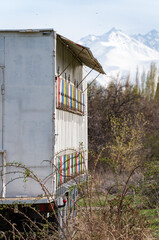 Vertical photo of a mobile apiary on wheels with colorful beehives with bees flying to the hive...