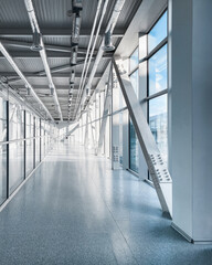 Empty long corridor in the airport terminal. Diminishing perspective view of long glass corridor...