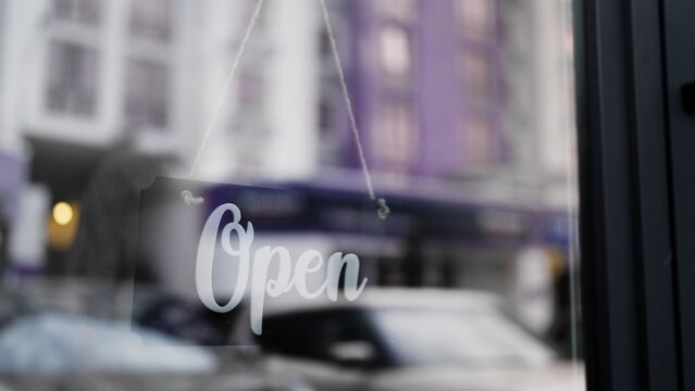 Open sign board on glass door of cafe, coffee shop is open for customers