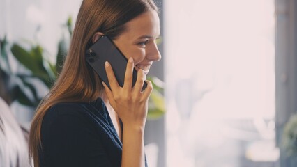 Happy young woman answering phone call, joyful communication and positive news