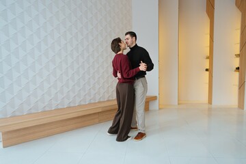 Couples dance in modern studio space with geometric wall design
