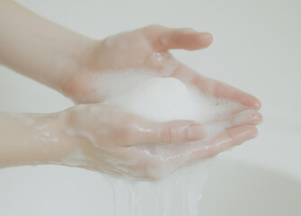 Fototapeta premium Washing hands with soap and water in a sink. Hygienic hand cleansing is essential to prevent the spread of germs and maintain personal health and wellness.