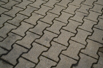 Gray concrete paving blocks arranged in zigzag patterGray concrete paving blocks arranged in zigzag...