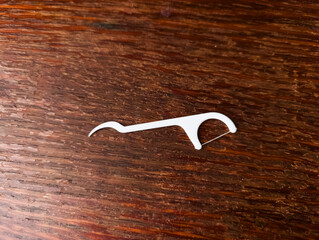 A white metal hook on a wooden surface