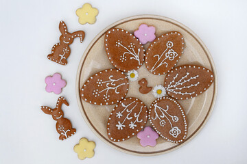 Plate with Easter gingerbread cookies of various shapes and daisy flowers