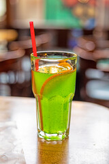 natural lemonade with a slice of orange in a glass with a red drinking straw