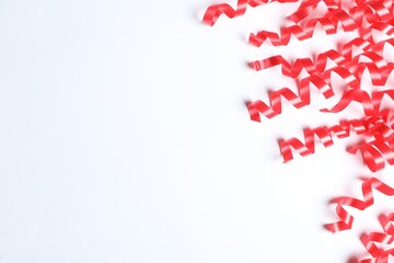 Red serpentine streamers on white background, top view