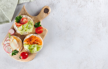 Set rice cakes, sandwiches with fresh vegetables, salmon, ham, protein. Healthy, low-calorie, diet snacks. Copy space.