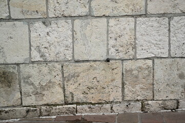 Natural stone wall texture with rectangular beige and gray blocks. Rough surface and organic patterns ideal for architectural backgrounds and design materials.