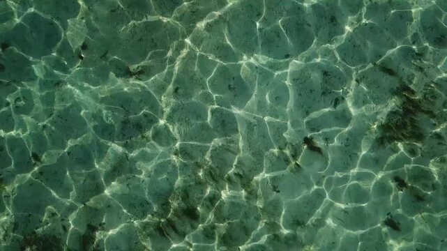 The texture of the ocean waves gently reflecting the golden hues of sunset, with soft ripples and a serene, shimmering surface that captures the fading light.