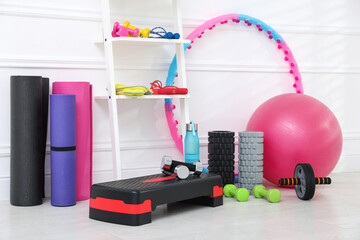 Different fitness equipment near white wall indoors