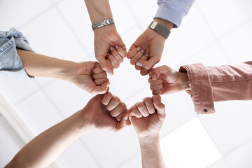 Unity concept. People holding fists together indoors, bottom view