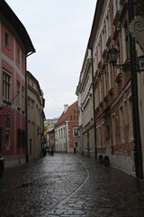 Historic European street with old buildings and church tower. Narrow cobblestone alley with traditional architecture, ideal for travel, tourism, and cultural heritage themes.