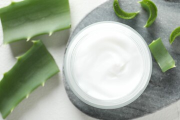 Cream and aloe leaves on white background, flat lay