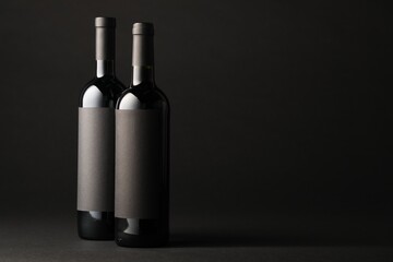 Bottles of wine on black background, space for text