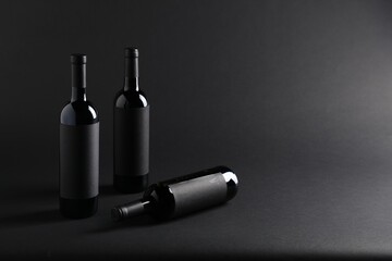 Bottles of wine on black background, space for text