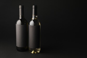 Bottles of wine on black background, space for text