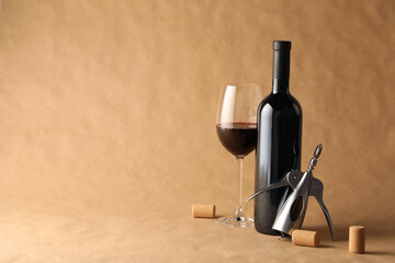 Tasty red wine in glass, bottle, corks and wing corkscrew on parchment paper, space for text