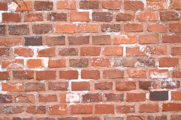 Old red brick wall texture with white efflorescence and weathered surface. Vintage masonry background for design, architecture, construction, and restoration projects. Rough textured red bricks with m
