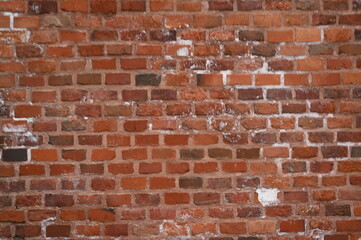 Old red brick wall texture with white efflorescence and weathered surface. Vintage masonry background for design, architecture, construction, and restoration projects. Rough textured red bricks with m