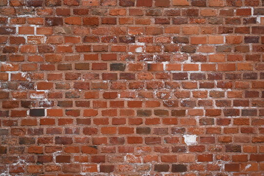 Old red brick wall texture with white efflorescence and weathered surface. Vintage masonry background for design, architecture, construction, and restoration projects. Rough textured red bricks with m - Powered by Adobe